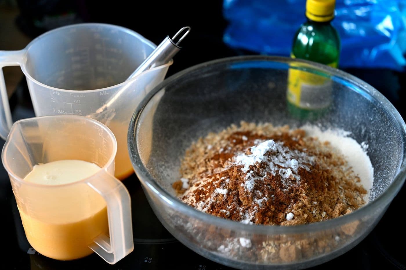 A collection of baking ingredients ready for mixing in a glass bowl on the kitchen counter.